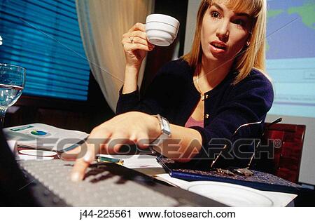 Businesswoman working on a desk with laptop and cup of coffe in an office View Large Photo Image Stock Image - Businesswoman working on a desk with laptop and cup of coffe in an office. Fotosearch
