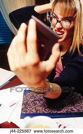 Businesswoman working on a desk with handheld in an office View Large Photo Image Stock Photo - Businesswoman working on a desk with handheld in an office. Fotosearch