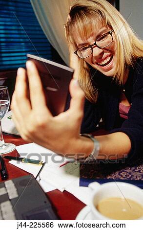 Stock Photograph - Businesswoman working on a desk with handheld in an office. Fotosearch