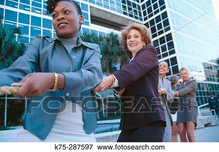 Stock Photo - businesswomen in a tug of war. Fotosearch