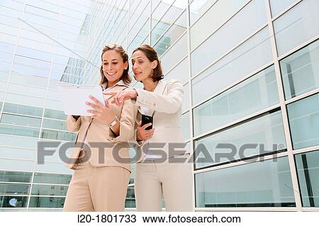 Businesswomen using digital tablet View Large Photo Image Stock Image - Businesswomen using digital tablet. Fotosearch