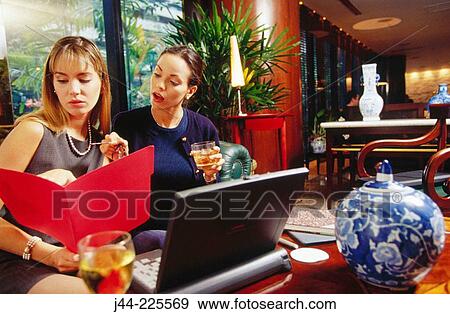 Businesswomen working in a hotel lounge View Large Photo Image Stock Photo - Businesswomen working in a hotel lounge. Fotosearch