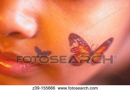 Stock Photograph - Butterfly tattoo on cheek.. Fotosearch