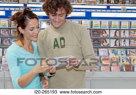 Stock Image - Buying music CD at shopping center. Fotosearch