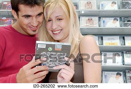 Stock Image - Buying music CD at shopping center. Fotosearch