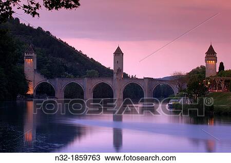 Stock Image - Cahors, Valentre bridge, Pont Valentre at Dusk, Lot River, Lot departament, Quercy, Via Podiensis, Way of St James, France. Fotosearch