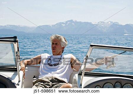 CALIFORNIA Lake Tahoe Adult male in sleeveless shirt relax on motor boat, sunglasses around neck, hold fishing rod in hand View Large Photo Image Stock Image - CALIFORNIA Lake Tahoe Adult male in sleeveless shirt relax on motor boat, sunglasses around neck, hold fishing rod in hand. Fotosearch