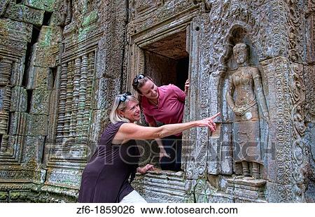 Cambodia, Siem Reap, Angkor Wat, Ta Prohm temple, Mother and daughter watching ruins View Large Photo Image Stock Photograph - Cambodia, Siem Reap, Angkor Wat, Ta Prohm temple, Mother and daughter watching ruins. Fotosearch