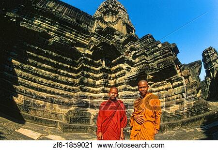 Stock Image - Cambodia, Siem Reap, Angkor Wat, Temple with monks on stones. Fotosearch