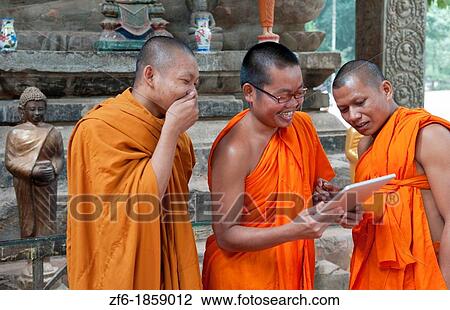 Cambodia, Siem Reap, Young monks laughing and playing at digital tablet View Large Photo Image Stock Image - Cambodia, Siem Reap, Young monks laughing and playing at digital tablet. Fotosearch