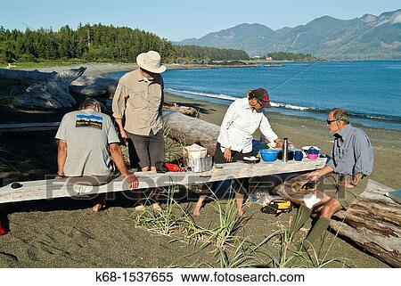 Stock Photography - campers cook a meal on the beach on Nootka Island, BC, Canada. Fotosearch
