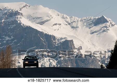 Canada, BC, Glacier National Park Car on the crest of a hill on Highway 1 passing through the Rocky Mountains in spring View Large Photo Image Stock Photo - Canada, BC, Glacier National Park Car on the crest of a hill on Highway 1 passing through the Rocky Mountains in spring. Fotosearch