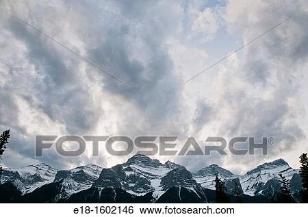 Canada, BC, Golden. Clouds rising above Rocky Mountains View Large Photo Image Stock Photograph - Canada, BC, Golden. Clouds rising above Rocky Mountains. Fotosearch