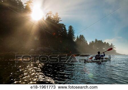 Canada, BC, Vancouver Island. Broken Island Group, part of the Pacific Rim National Park on the Pacific coast. Man paddles his kayak past the shore of Clarke Island. View Large Photo Image Stock Image - Canada, BC, Vancouver Island. Broken Island Group, part of the Pacific Rim National Park on the Pacific coast. Man paddles his kayak past the shore of Clarke Island.. Fotosearch