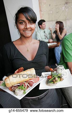 Stock Photo - Canada, Montreal, Avenue du Parc, Bar Pullman, Asian waitress serves food, plate,. Fotosearch