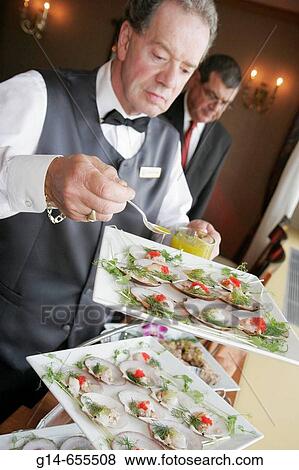 Stock Photo - Canada, Montreal, Fairmont Queen Elizabeth Hotel, male waiter, hors d? oeuvres reception, prepare, food, hospitality,. Fotosearch