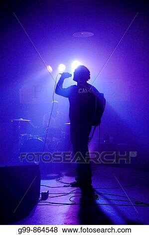 Canada, Ontario, Windsor. A folk singer backlit in blue light performing at a bar. View Large Photo Image Stock Photo - Canada, Ontario, Windsor. A folk singer backlit in blue light performing at a bar.. Fotosearch