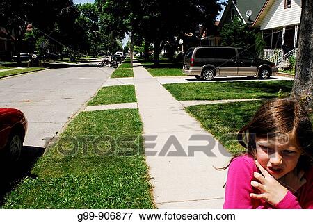 Canada, Ontario, Windsor. Girl in pink blouse holding neck while running along sidewalk. View Large Photo Image Stock Photo - Canada, Ontario, Windsor. Girl in pink blouse holding neck while running along sidewalk.. Fotosearch