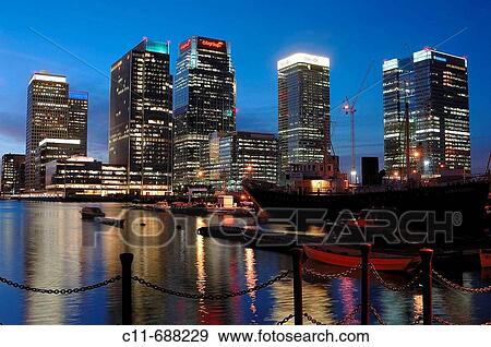 Canary wharf financial district showing skyscraper towers at night dusk evening overlooking water with reflections and ships docked in water isle of dogs. London. England. UK View Large Photo Image Stock Photo - Canary wharf financial district showing skyscraper towers at night dusk evening overlooking water with reflections and ships docked in water isle of dogs. London. England. UK. Fotosearch