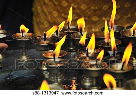 Stock Photo - Candle flames at the temple. Fotosearch