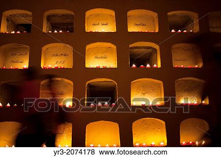 Stock Photo - Candles decorate graves of the San Miguel cemetery during the Day of the Dead celebrations in Oaxaca, Mexico. The Day of the Dead celebration is a tradition that honors the deceased.. Fotosearch