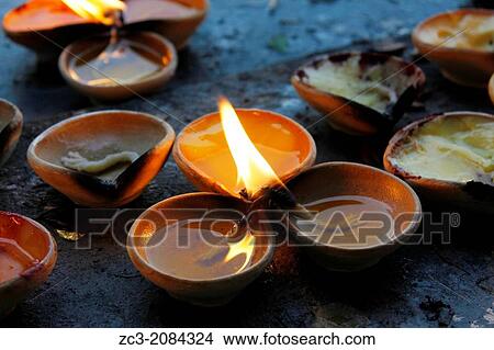 Candles with oil inside the sacred temple near Batu Caves who are a set of caves, some of which have been converted into temples, in a limestone hill located 10 kilometers north of Kuala Lumpur, Malaysia. View Large Photo Image Picture - Candles with oil inside the sacred temple near Batu Caves who are a set of caves, some of which have been converted into temples, in a limestone hill located 10 kilometers north of Kuala Lumpur, Malaysia.. Fotosearch