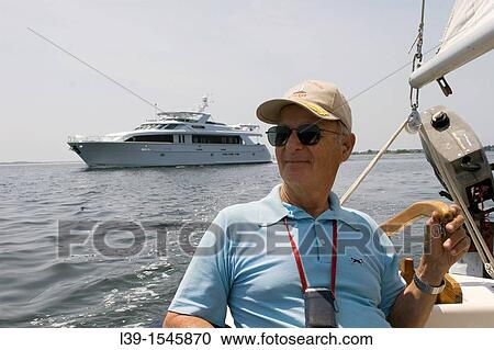 captain of a small sailing ship on Long Island sound off Stonington, CT, USA. View Large Photo Image Stock Image - captain of a small sailing ship on Long Island sound off Stonington, CT, USA.. Fotosearch