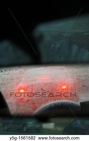 Stock Image - car driving in heavy rain on rural country road. Fotosearch
