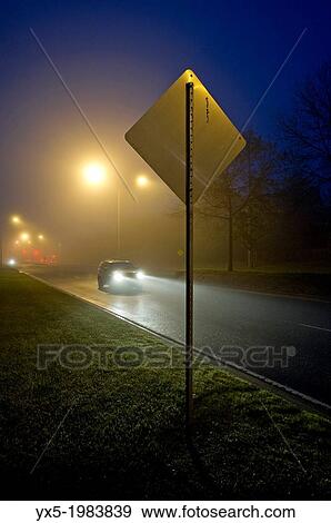 Stock Photo - Car passing a street sign at night.. Fotosearch