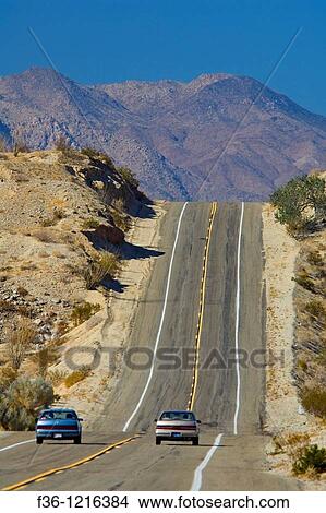 Car passing on two lane desert road approaching a hill, Anza Borrego Desert State Park, San Diego County, California View Large Photo Image Picture - Car passing on two lane desert road approaching a hill, Anza Borrego Desert State Park, San Diego County, California. Fotosearch