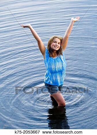 Carefree young girl standing in lake View Large Photo Image Stock Photo - Carefree young girl standing in lake. Fotosearch
