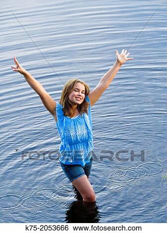 Carefree young girl standing in lake View Large Photo Image Stock Photograph - Carefree young girl standing in lake. Fotosearch