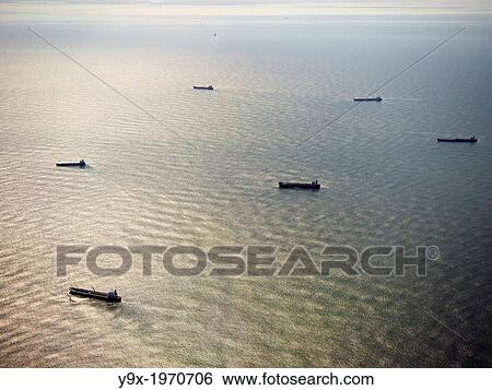 Cargo ships floating in the ocean. View Large Photo Image Stock Photograph - Cargo ships floating in the ocean.. Fotosearch