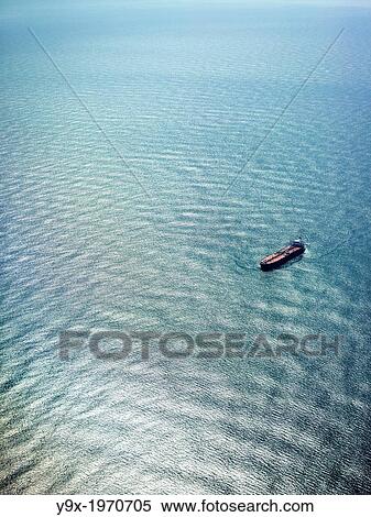 Stock Photography - Cargo ships floating in the ocean.. Fotosearch