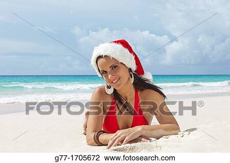 Stock Image - Caribbean Barbados Woman on a beach with Santa hat.. Fotosearch