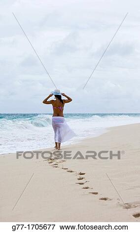 Stock Photo - Caribbean Barbados Woman on a deserted beach.. Fotosearch