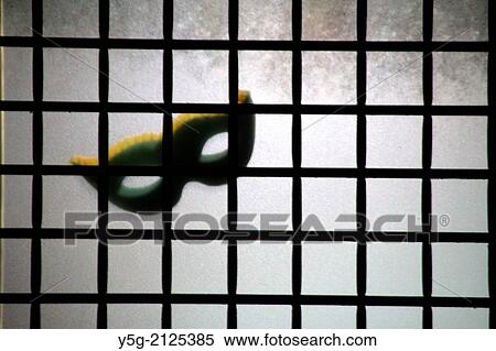 Stock Photography - carnival mask on property window at night in rome italy. Fotosearch