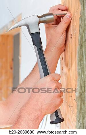 Stock Image - Carpenter with hammer with carbon fiber handle. Construction of residential building. Donostia. San Sebastian. Gipuzkoa. Basque Country. Spain.. Fotosearch