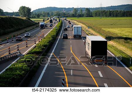 Cars drive from a highway construction site on the highway View Large Photo Image Stock Photography - Cars drive from a highway construction site on the highway. Fotosearch