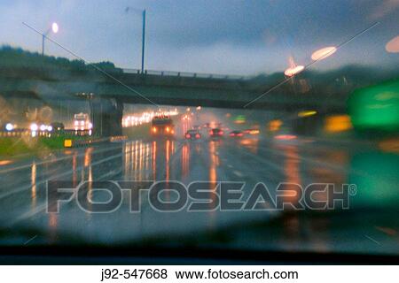 Cars driving along wet road at dusk 2006. New Jersey Turnpike, USA View Large Photo Image Stock Photo - Cars driving along wet road at dusk 2006. New Jersey Turnpike, USA. Fotosearch