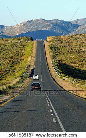 Stock Photo - Cars on the dead straight national road N7 near Springbok in Northern direction towards the border with Namibia, South Africa. Fotosearch