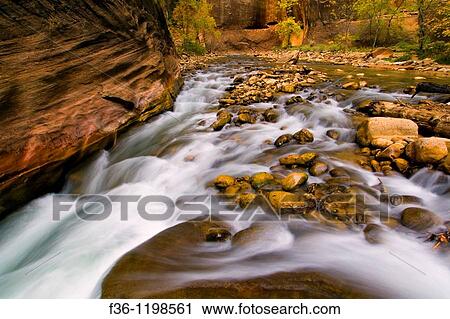 Stock Image - Cascade water over rocks in the Virgin River Narrows, Zion National Park, Utah. Fotosearch