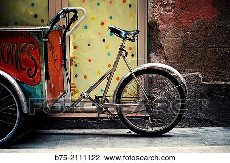 Stock Image - Casting tricycle parked on a street in Barcelona, Spain, Europe.. Fotosearch