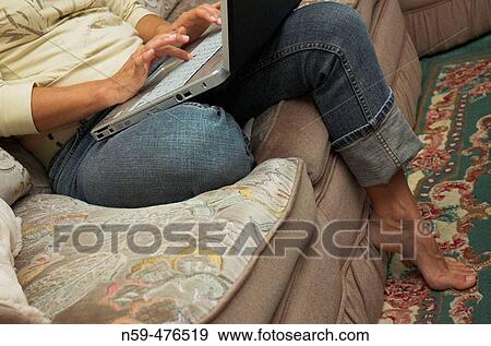 Casual female on sofa using laptop computer. View Large Photo Image Stock Photo - Casual female on sofa using laptop computer.. Fotosearch
