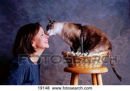 Stock Photo - Cat licking woman's face. Fotosearch