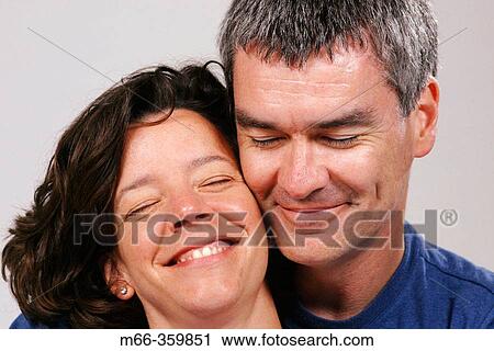 Caucasian American man and woman touching cheeks with eyes closed, enjoying a happy moment together View Large Photo Image Stock Image - Caucasian American man and woman touching cheeks with eyes closed, enjoying a happy moment together. Fotosearch