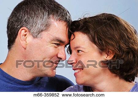 Stock Image - Caucasian American man and woman touching foreheads, sharing a happy, intimate moment.. Fotosearch