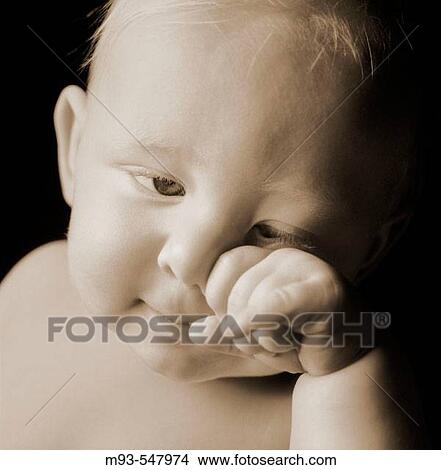 Caucasian baby, obviously tired, rubbing face. Not crying. View Large Photo Image Picture - Caucasian baby, obviously tired, rubbing face. Not crying.. Fotosearch