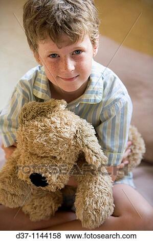 Caucasian boy holding a cuddly toy in bed View Large Photo Image Stock Photo - Caucasian boy holding a cuddly toy in bed. Fotosearch