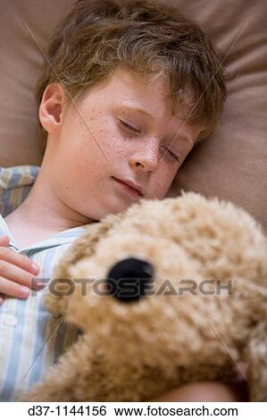 Caucasian boy sleeping with a cuddly toy in bed View Large Photo Image Stock Photograph - Caucasian boy sleeping with a cuddly toy in bed. Fotosearch